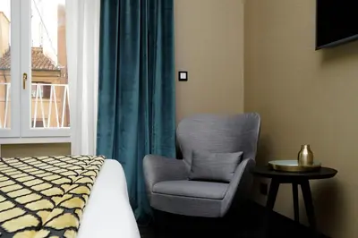 a bedroom with a chair and a bed and a window at BQ House Colosseo Luxury Rooms in Rome