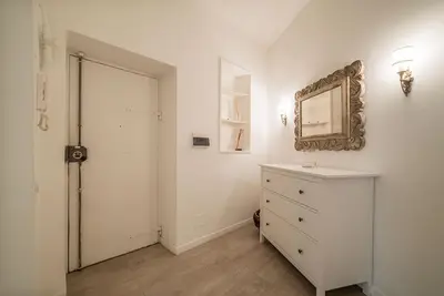 a white bedroom with a dresser and a mirror at Rome Sweet Home near Metro Flaminio in Rome