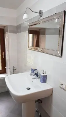 a white bathroom with a sink and a mirror at Il Giardino Al Pigneto in Rome