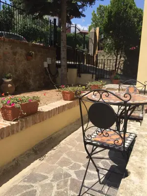 a wrought iron table and bench on a patio at Il Giardino Al Pigneto in Rome