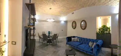 a living room with a blue couch and a table at LuMa Suite Via Veneto - Your luxury style 22 in Rome