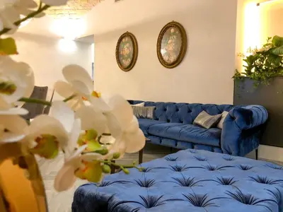 a living room with blue couches and white flowers at LuMa Suite Via Veneto - Your luxury style 22 in Rome