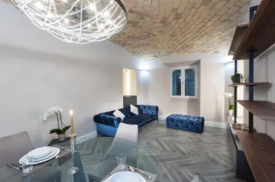 a living room with a glass table and a blue couch at LuMa Suite Via Veneto - Your luxury style 22 in Rome