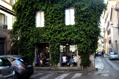 a building covered in ivy with people sitting in a restaurant at Domus Real Cardello in Rome