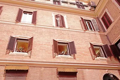 a brick building with windows with plants in them at Domus Real Cardello in Rome