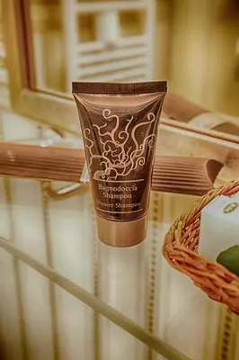 a container of sunscreen sitting on top of a table at Domus Real Cardello in Rome