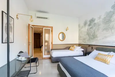 a hotel room with two beds and a table at ROMAC San Saba 5-Bedroom and Terrace near Ostiense in Rome