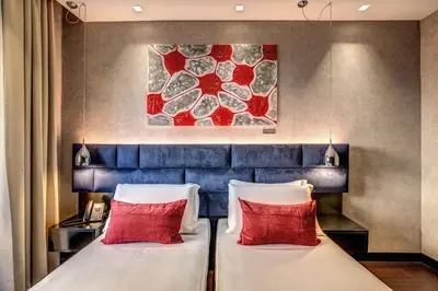 two beds in a hotel room with red pillows at Prassede Palace Hotel in Rome