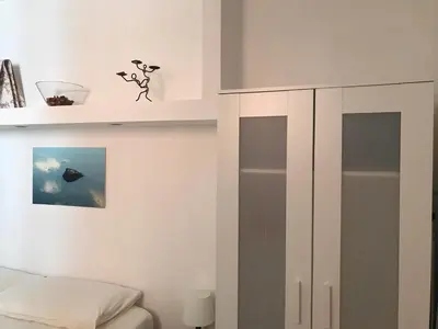 a bedroom with a bed and a white cabinet at La Casa del Fotografo in Rome