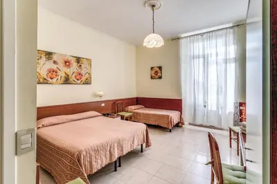 a hotel room with two beds and a window at Hotel Katty in Rome