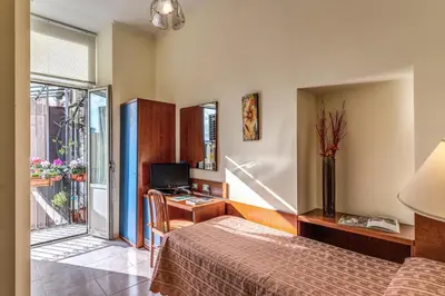 a bedroom with a bed and a desk with a computer at Hotel Katty in Rome