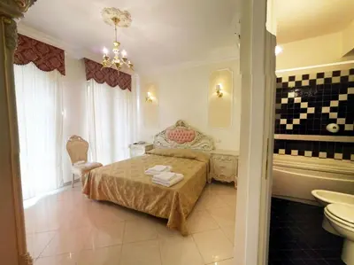 a bedroom with a bed and a tub and a sink at Colosseo Rooms Imperial Rome in Rome