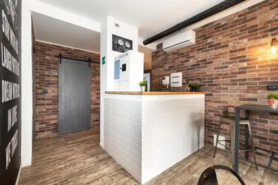 a bar in a brick walled room with a table at co.sleep in Rome