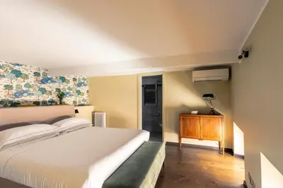 a bedroom with a white bed and a wooden floor at ROMAC Fontanella Borghese Palace in Rome