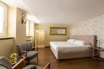 a bedroom with a bed and a table and chairs at ROMAC Fontanella Borghese Palace in Rome
