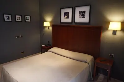 a bedroom with a bed and three pictures on the wall at Hotel Taormina in Rome