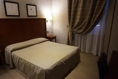 a small bedroom with a bed and a window at Hotel Taormina in Rome