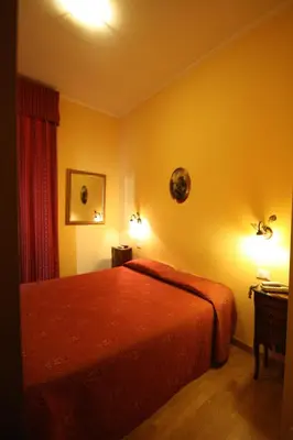 a bedroom with a bed and two lights on the wall at Hotel Termini in Rome