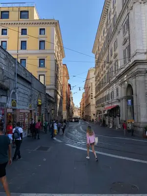 a woman walking down a city street with buildings at Hotel Termini in Rome