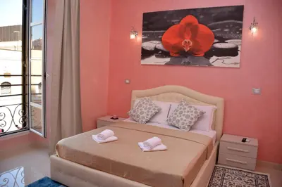 a bedroom with a bed with a red flower on the wall at Rome Innitaly Affittacamere o GuestHouse in Rome