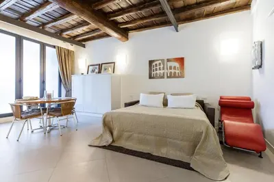 a bedroom with a bed and a table with chairs at Maison Romana Loft in Rome