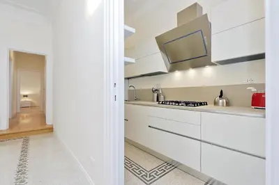 a kitchen with white cabinets and a stove at Modern Apartment Quirina 300 mt from Vatican in Rome