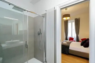 a bathroom with a shower and a bedroom with a bed at Modern Apartment Quirina 300 mt from Vatican in Rome