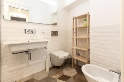 a white bathroom with a sink and a toilet at Elegant Apartment in the Center of Rome! in Rome