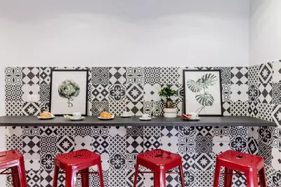 a bar with red stools and black and white tiles at MARCONI 94 - APARTMENT&PRIVATE ROOMS in Rome
