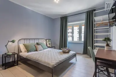 a bedroom with a bed and a table and a desk at MARCONI 94 - APARTMENT&PRIVATE ROOMS in Rome