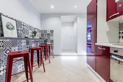 a kitchen with red stools and black and white tiles at MARCONI 94 - APARTMENT&PRIVATE ROOMS in Rome