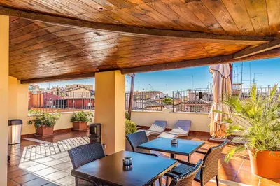a patio with tables and chairs on a balcony at Relais Trevi 95 Boutique Hotel in Rome