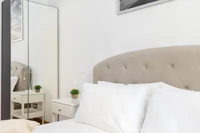 a bedroom with a white bed and a large mirror at A World Aparts - 32 Calabria in Rome