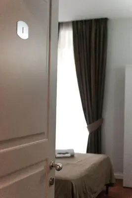 a room with a bed and a window with a curtain at Elle Cavour Guest House in Rome