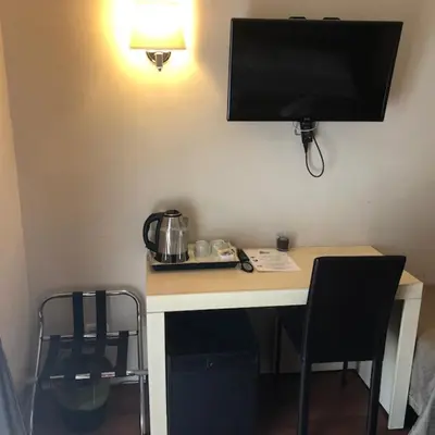 a room with a desk with a television on a wall at Elle Cavour Guest House in Rome