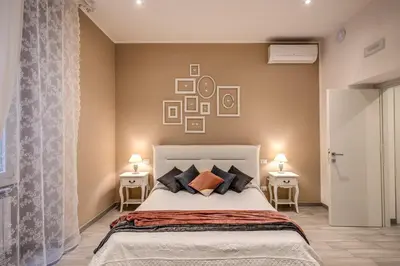 a bedroom with a bed with two tables and two lamps at Vatican Royal Apartment in Rome
