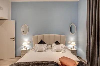 a bedroom with a large white bed with two lamps at Vatican Royal Apartment in Rome