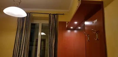 a hallway with a light and a door and a mirror at Holiday Roma in Rome