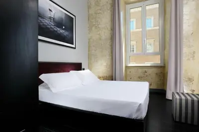 a bedroom with a white bed and a window at Suite Art Navona in Rome