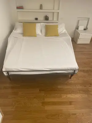 a bed with white sheets and pillows in a room at House Domusella in Rome