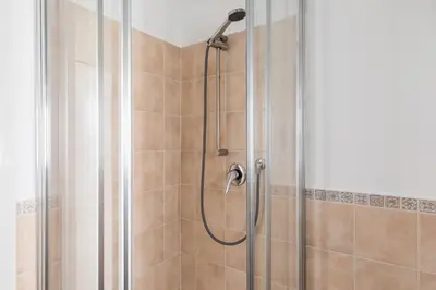 a shower with a shower head in a bathroom at A World Aparts - 105 Pellegrino in Rome
