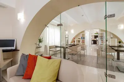 a living room with a white couch with colorful pillows at Demetra Hotel in Rome
