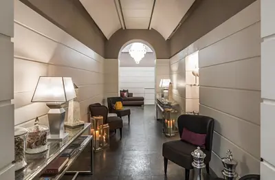 a salon with chairs and tables in a room at The Independent Hotel in Rome