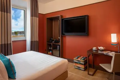 a hotel room with a bed and a television at The Independent Hotel in Rome