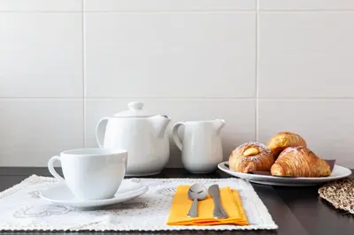 a table with a cup of coffee and croissants at Leonardo Suite Navona in Rome
