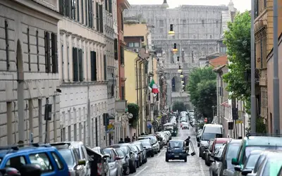 a city street filled with lots of parked cars at LATERANO 250 - COLOSSEO in Rome