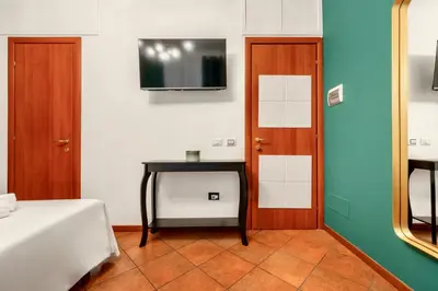 a room with a bed and a table and a tv at Colosseo Relais in Rome