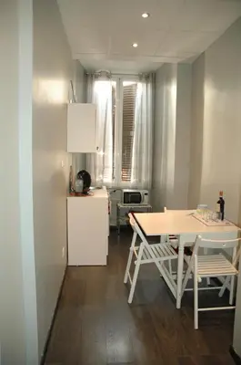 a kitchen with a table and a white refrigerator at Morfeo Suite in Rome