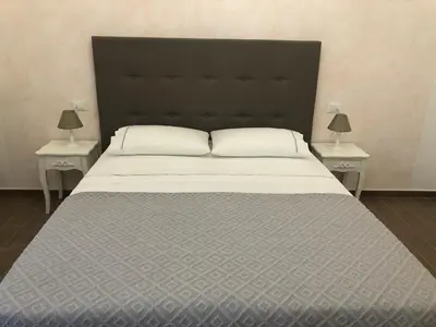 a large bed with a black headboard and two tables at S.Apollonia Suite Trastevere in Rome