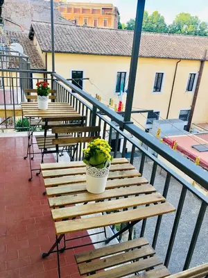 a balcony with wooden benches and potted plants on it at S.Apollonia Suite Trastevere in Rome